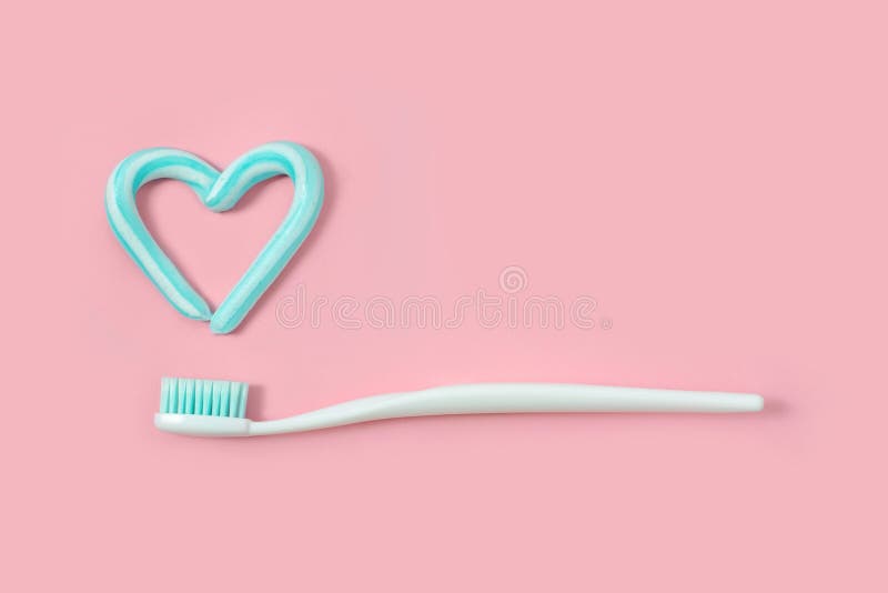 Los cepillos de dientes y la turquesa colorean la crema dental en la forma del corazón en fondo rosado Concepto dental y de la at fotos de archivo Los cepillos de dientes y la turquesa colorean la crema dental en la forma del corazón en fondo rosado Concepto dental y de la at fotos de archivo
