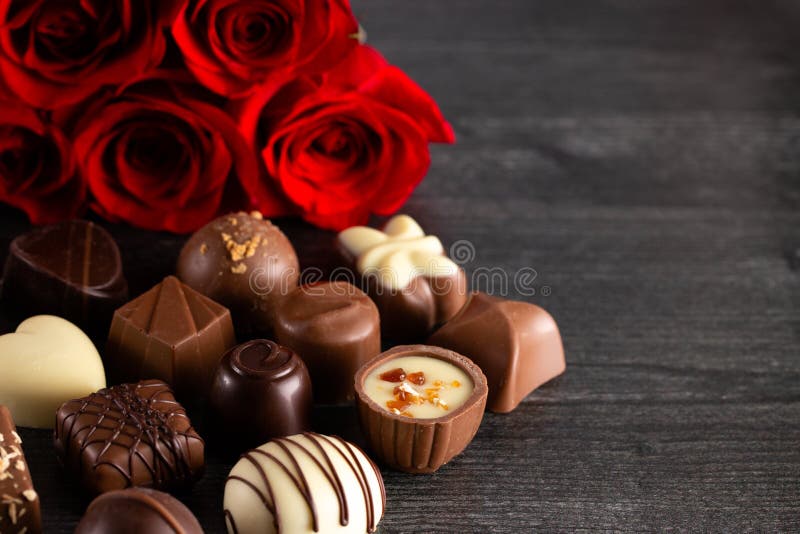 Los chocolates y las rosas perfeccionan la combinación para la mujer usted amor fotos de archivo libres de regalías