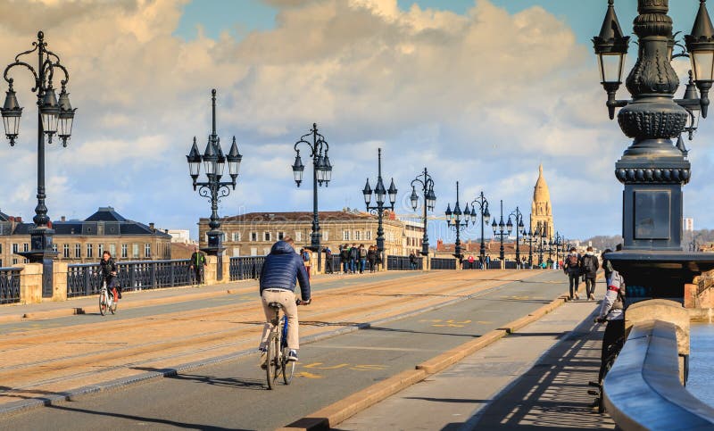 Los ciclistas y los peatones dan un paseo en el puente del río de Burdeos imagen de archivo libre de regalías Los ciclistas y los peatones dan un paseo en el puente del río de Burdeos imagen de archivo libre de regalías