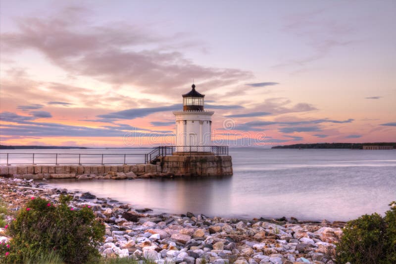 The Bug Light, at the end of the breakwater in Portland Maine, is illuminated by the brilliant colours of sunset on a summer evening. The Bug Light, at the end of the breakwater in Portland Maine, is illuminated by the brilliant colours of sunset on a summer evening.