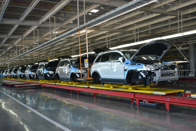 Los coches se colocan en la línea del transportador de nave de montaje Automóvil favorable imagen de archivo libre de regalías Los coches se colocan en la línea del transportador de nave de montaje Automóvil favorable imagen de archivo libre de regalías