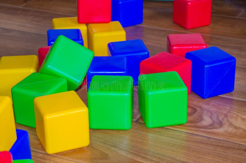 Los Cubos Plásticos Coloridos Para Los Juegos De Los Niños Se Dispersan En El Piso De Imagen de archivo - Imagen de color, cubos: 143926689