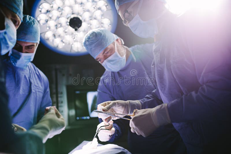 Los doctores combinan realizando procedimiento quirúrgico en teatro de operaciones imágenes de archivo libres de regalías Los doctores combinan realizando procedimiento quirúrgico en teatro de operaciones imágenes de archivo libres de regalías