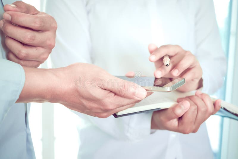 Los doctores de sexo femenino y los médicos de sexo masculino discuten la información de perfil paciente imágenes de archivo libres de regalías Los doctores de sexo femenino y los médicos de sexo masculino discuten la información de perfil paciente imágenes de archivo libres de regalías