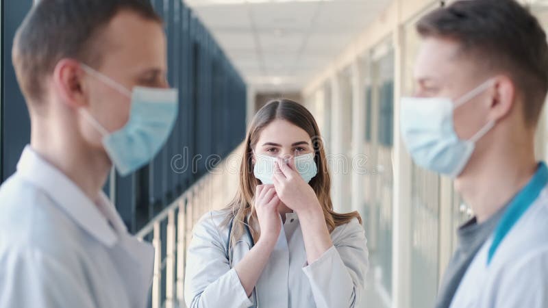 Los doctores en túnicas están compartiendo máscaras desechables y poniéndolas en caras