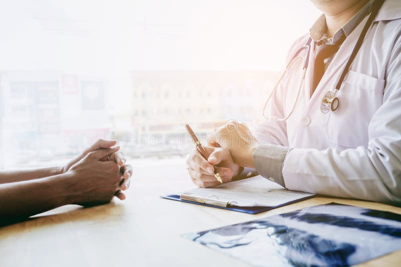 Los doctores y los pacientes se sientan y hablan En la tabla cerca de la ventana imagen de archivo Los doctores y los pacientes se sientan y hablan En la tabla cerca de la ventana imagen de archivo