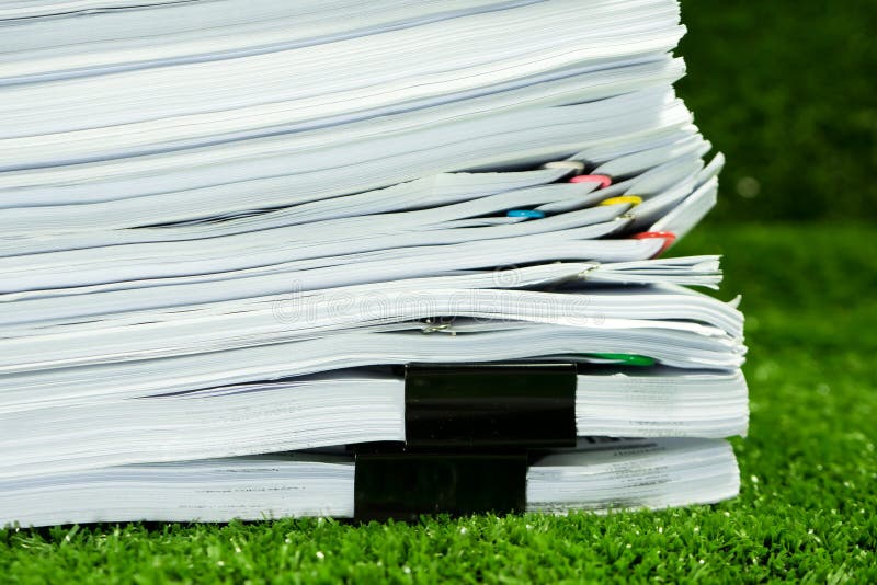 Los documentos llenan en hierba en tierra de la reserva del concepto imagen de archivo libre de regalías Los documentos llenan en hierba en tierra de la reserva del concepto imagen de archivo libre de regalías