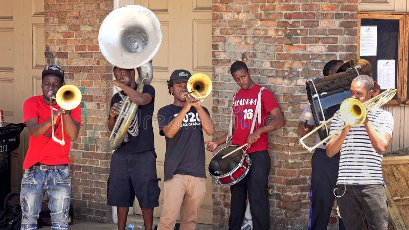 NEW ORLEANS, LOUISIANA - MAY 7th: Young street performers play music for tips in the historic French Quarter of New Orleans, Louisiana on May 7th, 2016. NEW ORLEANS, LOUISIANA - MAY 7th: Young street performers play music for tips in the historic French Quarter of New Orleans, Louisiana on May 7th, 2016