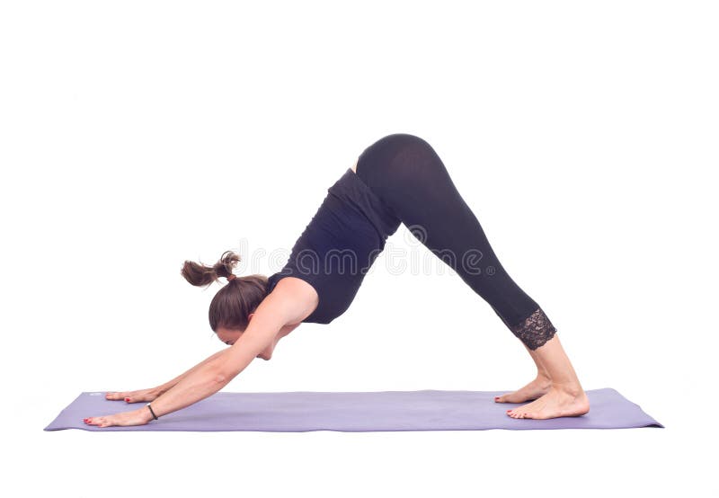 Los ejercicios practicantes/abajo de la yoga persiguen la actitud - Adho Mukha Svanasana foto de archivo Los ejercicios practicantes/abajo de la yoga persiguen la actitud - Adho Mukha Svanasana foto de archivo