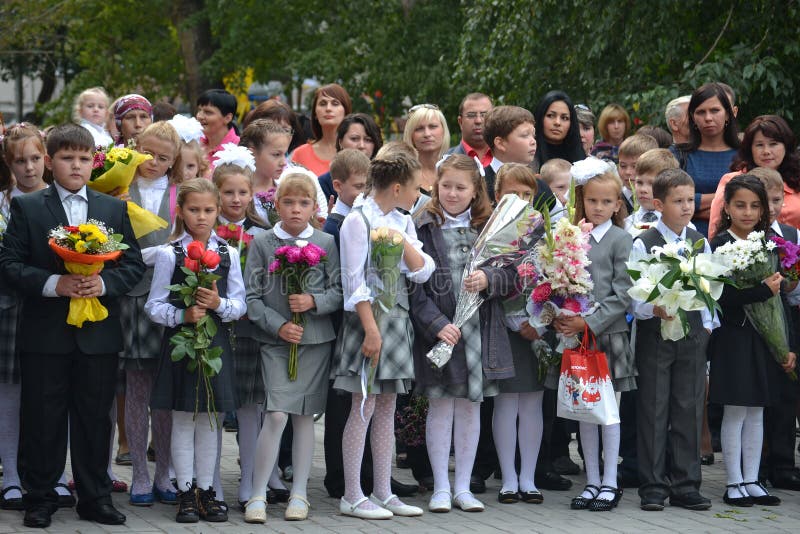Los estudiantes de la escuela se colocan con las flores en manos el 1 de septiembre. imagen de archivo Los estudiantes de la escuela se colocan con las flores en manos el 1 de septiembre. imagen de archivo