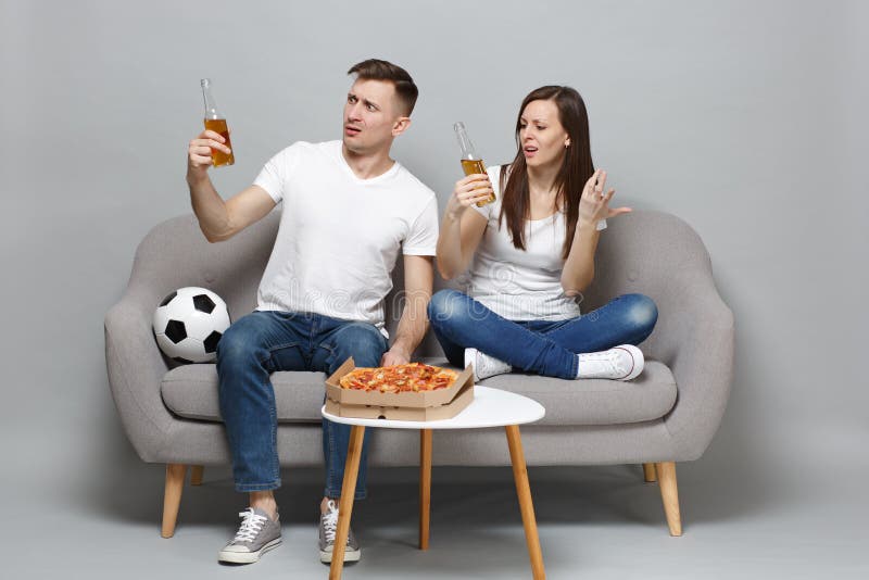 Los fanáticos del fútbol perplejos del hombre de la mujer de los pares animan para arriba el equipo preferido de la ayuda con el fotografía de archivo libre de regalías Los fanáticos del fútbol perplejos del hombre de la mujer de los pares animan para arriba el equipo preferido de la ayuda con el fotografía de archivo libre de regalías