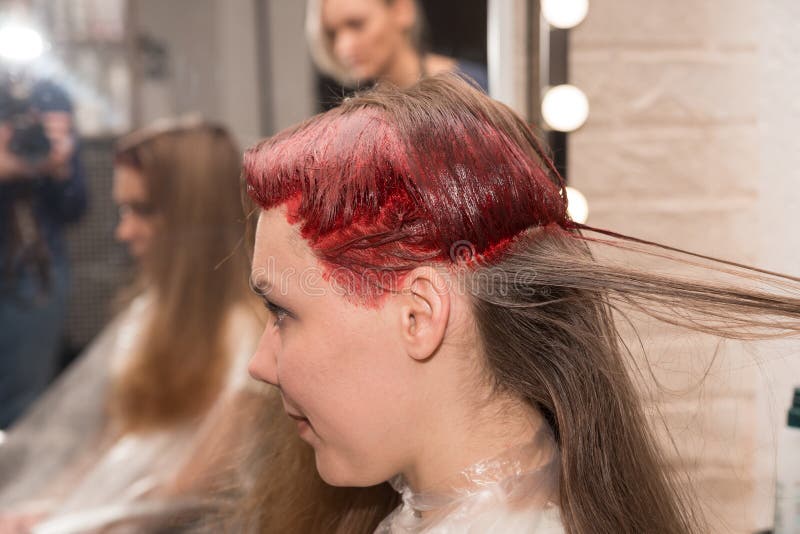 Los girl’s mitad-colorearon la cabeza durante coloración del cabello se reflejan en el espejo en el salón de los hairdresser’ imágenes de archivo libres de regalías Los girl’s mitad-colorearon la cabeza durante coloración del cabello se reflejan en el espejo en el salón de los hairdresser’ imágenes de archivo libres de regalías