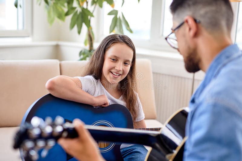 Los hombres pasan un momento especial con una niña que canta y toca la guitarra