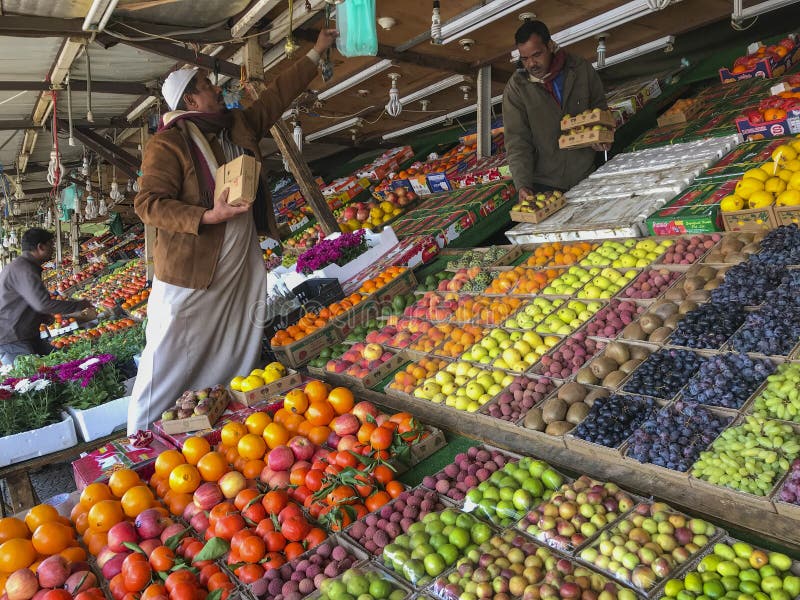 Los hombres árabes venden las frutas frescas en una mercado de la fruta en Taif, Makkah, la Arabia Saudita