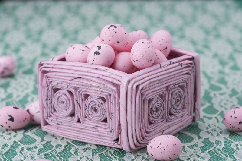 Los huevos de Pascua rosados en un rosa reciclaron la cesta de papel
