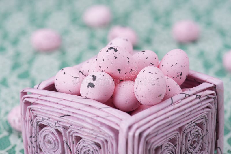 Los huevos de Pascua rosados en un rosa reciclaron la cesta de papel