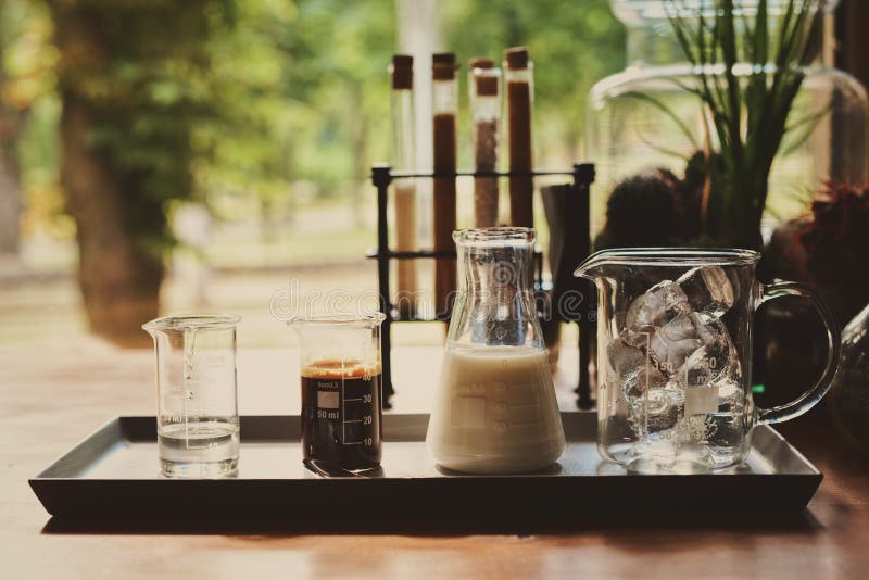Los ingredientes para hacer el latte fr?o del caf?, la leche del caf? express de los cubos de hielo y el jarabe dulce sirvieron e foto de archivo libre de regalías Los ingredientes para hacer el latte fr?o del caf?, la leche del caf? express de los cubos de hielo y el jarabe dulce sirvieron e foto de archivo libre de regalías