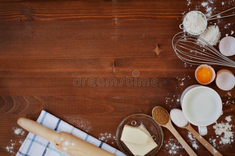 Los ingredientes para la pasta que cuece incluyendo la harina, huevos, leche, mantequilla, azúcar, baten y rodillo en fondo rústi