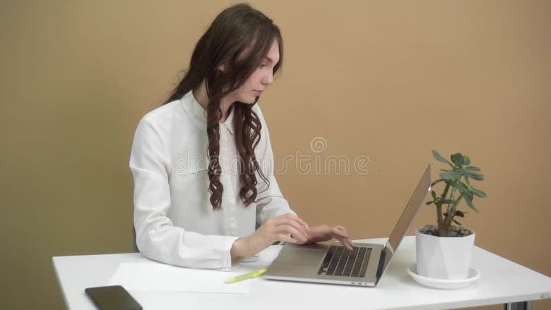Los jóvenes profesionales se involucran con la tecnología y toman notas en las estaciones de trabajo modernas almacen de video