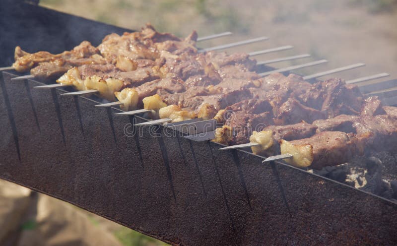 Los kebabs se fríen en la parrilla en el aire abierto fotografía de archivo Los kebabs se fríen en la parrilla en el aire abierto fotografía de archivo
