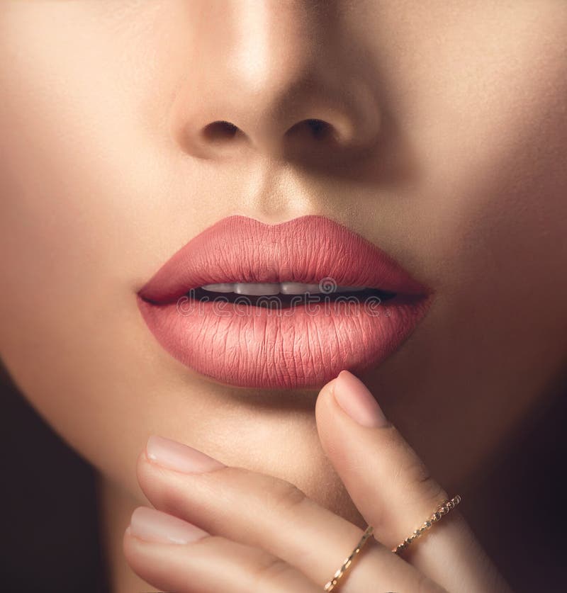 Los labios sensuales de la mujer perfecta con el lápiz labial mate beige