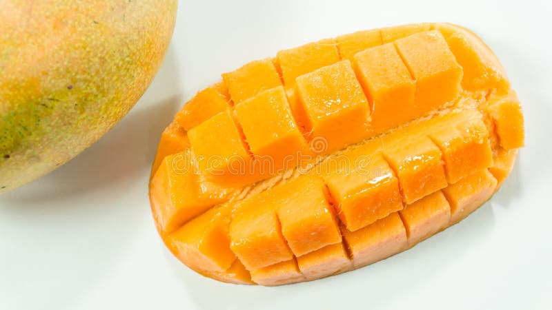 Los mangos maduros en el fondo blanco/cortaron el mango delicioso para comer imagen de archivo Los mangos maduros en el fondo blanco/cortaron el mango delicioso para comer imagen de archivo