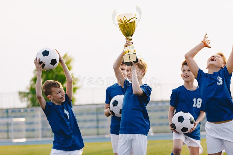 Los muchachos están animando para su victoria del equipo Niños felices que celebran éxito en el torneo de la juventud de los depo