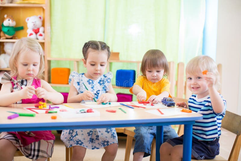 Los niños agrupan el aprendizaje de artes y de artes en guardería con interés imagen de archivo Los niños agrupan el aprendizaje de artes y de artes en guardería con interés imagen de archivo