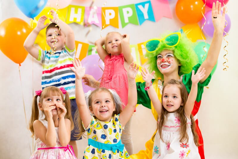 Los niños agrupan y payaso en fiesta de cumpleaños fotos de archivo Los niños agrupan y payaso en fiesta de cumpleaños fotos de archivo