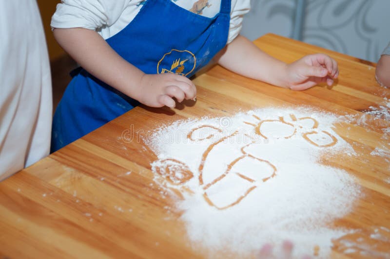 Los niños cocinan de la pasta y de la pintura en la harina foto de archivo libre de regalías