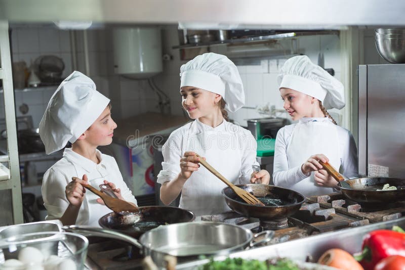 Los niños cocinan los huevos en la cocina en el restaurante fotos de archivo libres de regalías