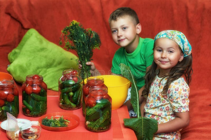 Los niños cocinan las verduras para el invierno foto de archivo