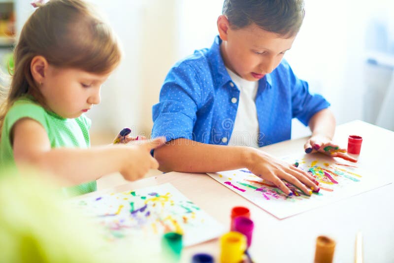 Los niños divertidos muestran a sus palmas la pintura pintada bellas arte creativas de las clases dos niños un muchacho y una ris foto de archivo Los niños divertidos muestran a sus palmas la pintura pintada bellas arte creativas de las clases dos niños un muchacho y una ris foto de archivo