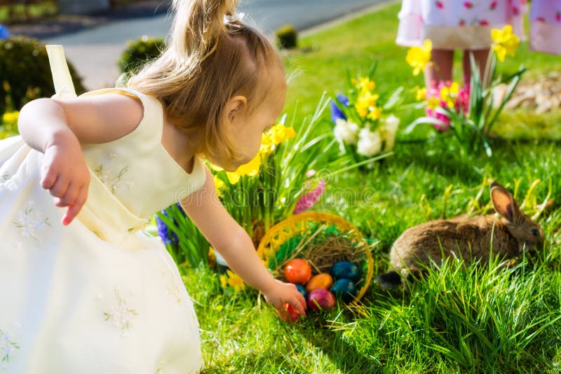 Los niños en el huevo de Pascua cazan con el conejito
