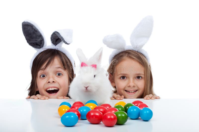 Los niños felices encontraron el conejito de pascua y el sitio de muerte de los huevos - aislados en blanco fotografía de archivo libre de regalías Los niños felices encontraron el conejito de pascua y el sitio de muerte de los huevos - aislados en blanco fotografía de archivo libre de regalías