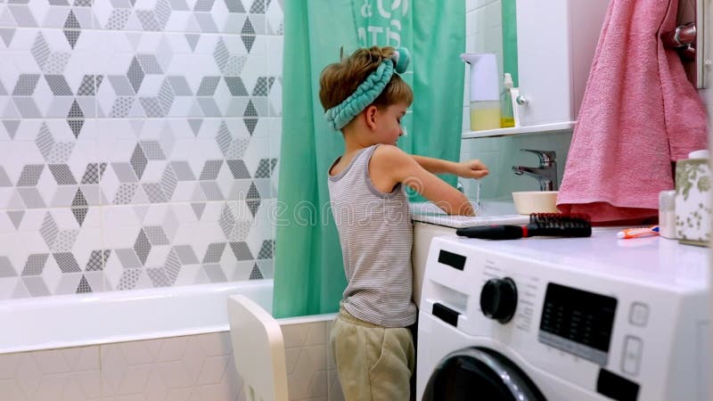 Los niños interactúan con la cortina de la ducha en el baño moderno por la tarde metrajes