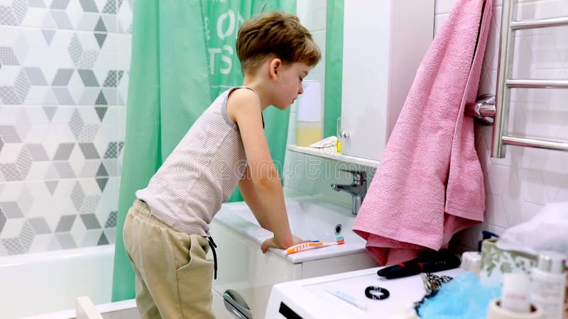 Los niños juegan y exploran en un baño lleno de objetos cotidianos y decoración colorida por la tarde almacen de metraje de vídeo