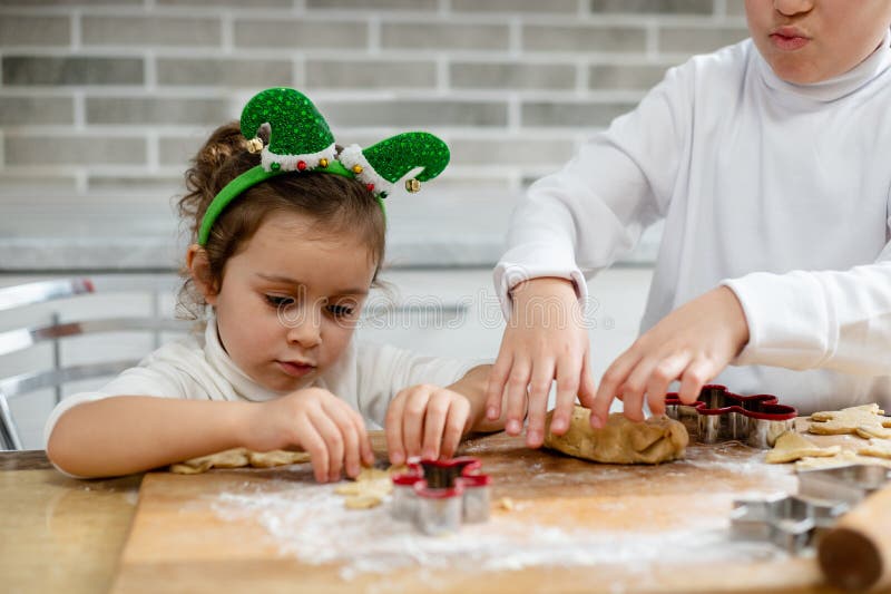 Los niños preparan el pan de jengibre de Navidad de masa. Cocinero del hermano y hermana fotos de archivo