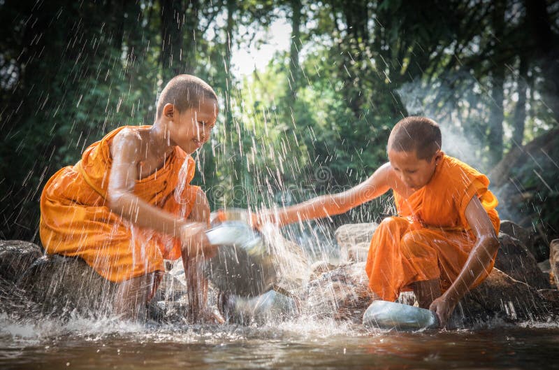 Los novatos budistas están limpiando los cuencos y están salpicando el agua en el s fotografía de archivo libre de regalías Los novatos budistas están limpiando los cuencos y están salpicando el agua en el s fotografía de archivo libre de regalías
