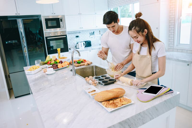 Los pares adolescentes asiáticos están ayudando a hacer la cena foto de archivo libre de regalías Los pares adolescentes asiáticos están ayudando a hacer la cena foto de archivo libre de regalías