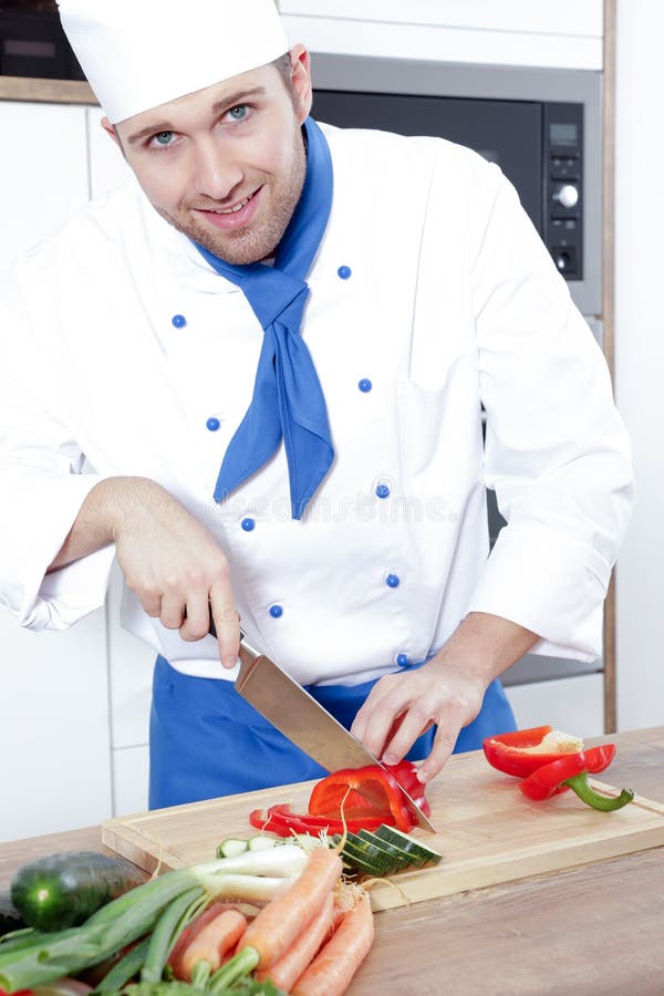 Los pares atractivos hermosos del hombre de la mujer como cocinero están cocinando en una cocina fotos de archivo Los pares atractivos hermosos del hombre de la mujer como cocinero están cocinando en una cocina fotos de archivo