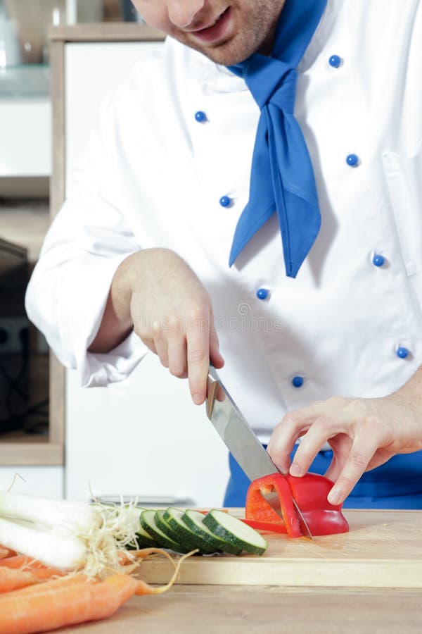 Los pares atractivos hermosos del hombre de la mujer como cocinero están cocinando en una cocina imagenes de archivo Los pares atractivos hermosos del hombre de la mujer como cocinero están cocinando en una cocina imagenes de archivo