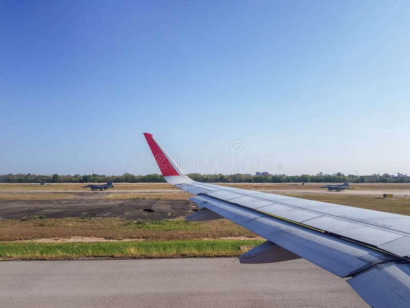 Pairs of Air Force fighter jets run pass commercial airplane in the airfield. only airliner`s wing spotted. Pairs of Air Force fighter jets run pass commercial airplane in the airfield. only airliner`s wing spotted.