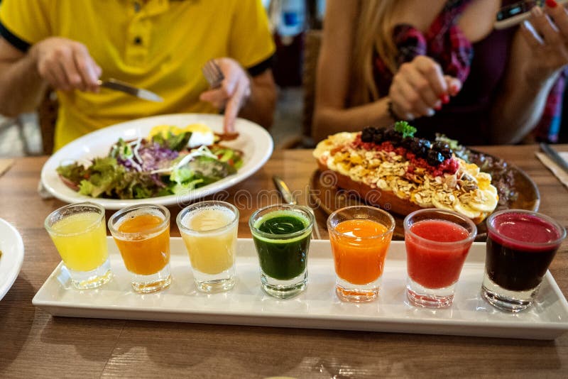 Los pares en amor están teniendo la cena en un restaurante con los platos hermosos y un sistema de jugos frescos fotos de archivo Los pares en amor están teniendo la cena en un restaurante con los platos hermosos y un sistema de jugos frescos fotos de archivo