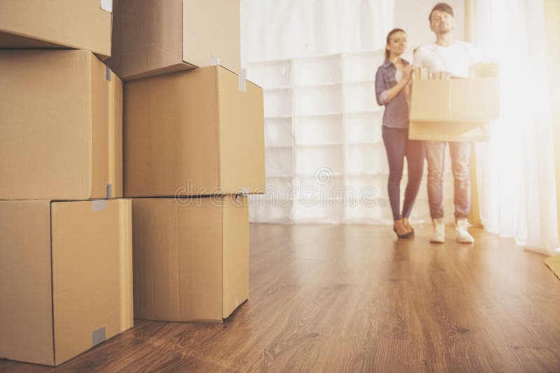Los pares felices jovenes que miran alrededor de su nuevo apartamento Mudanza, compra de la nueva habitación fotografía de archivo Los pares felices jovenes que miran alrededor de su nuevo apartamento Mudanza, compra de la nueva habitación fotografía de archivo