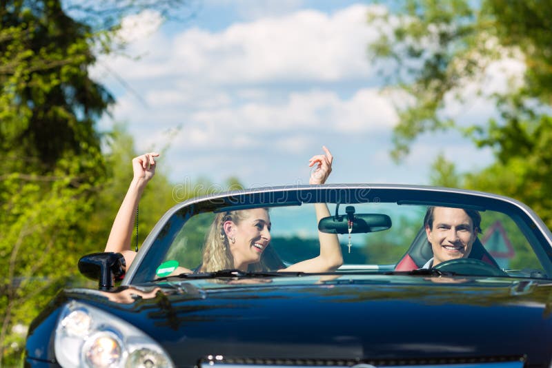 Los pares jovenes con el cabriolé en verano el día disparan imágenes de archivo libres de regalías Los pares jovenes con el cabriolé en verano el día disparan imágenes de archivo libres de regalías