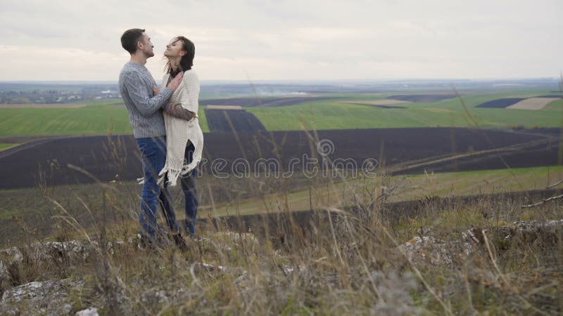 Los pares románticos en embracess y besos se colocan en el top de la roca