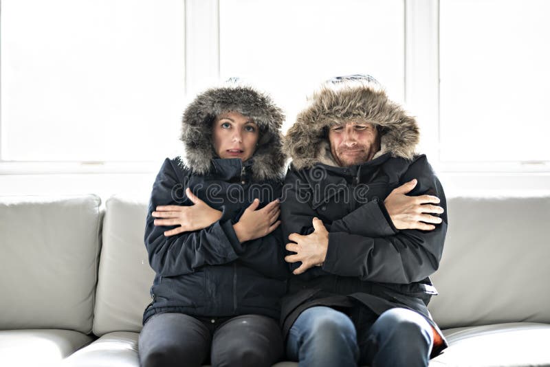 Los Pares Tienen Frío En El Sofá En Casa Con El Abrigo De Invierno Imagen De Archivo Imagen De