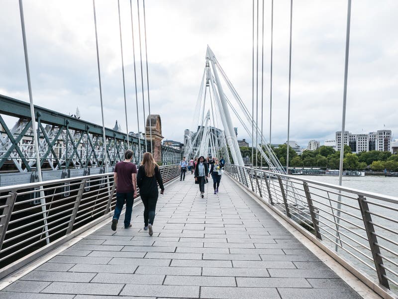 Los peatones cruzan el puente del jubileo sobre el río Támesis, Londres imagen de archivo Los peatones cruzan el puente del jubileo sobre el río Támesis, Londres imagen de archivo