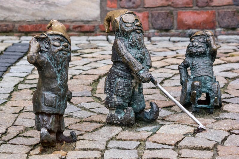 Los pequeños gnomos de bronce por nombre - Gluchak de la estatua sordo, persianas y W-Skers inhabilitados, grupo de Slepak del gn foto de archivo libre de regalías Los pequeños gnomos de bronce por nombre - Gluchak de la estatua sordo, persianas y W-Skers inhabilitados, grupo de Slepak del gn foto de archivo libre de regalías
